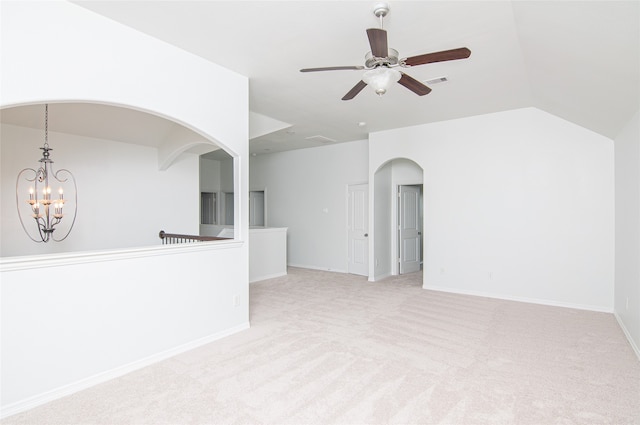 carpeted spare room featuring vaulted ceiling and ceiling fan with notable chandelier