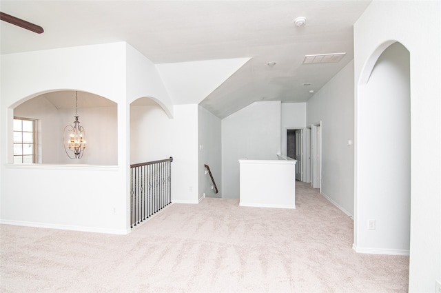 interior space with lofted ceiling, ceiling fan with notable chandelier, and light carpet