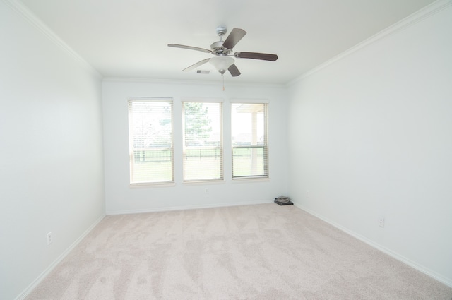 spare room featuring crown molding, ceiling fan, and light carpet