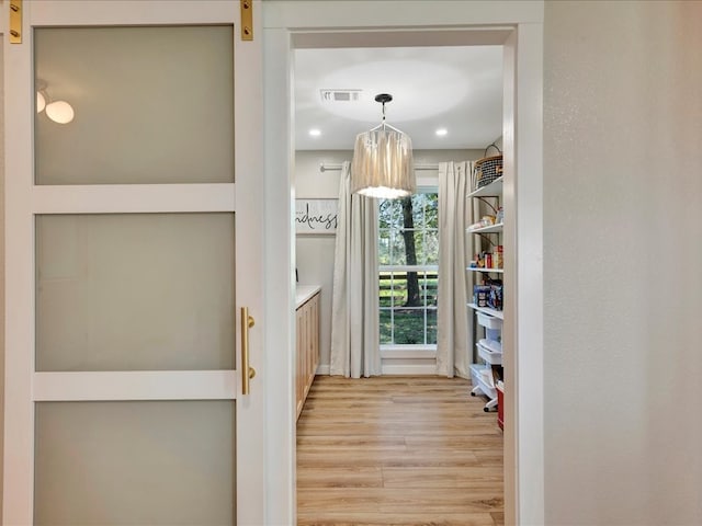 interior space featuring a barn door and light hardwood / wood-style flooring