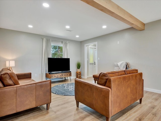 living room with light hardwood / wood-style floors and beamed ceiling