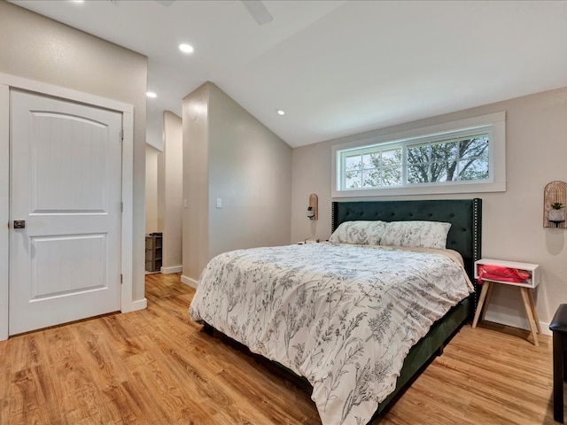 bedroom with ceiling fan, lofted ceiling, and light hardwood / wood-style floors