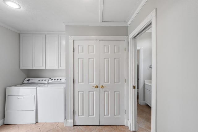 washroom with cabinets, washer and clothes dryer, ornamental molding, and light tile patterned floors