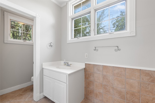 bathroom featuring tile patterned floors, toilet, crown molding, and vanity