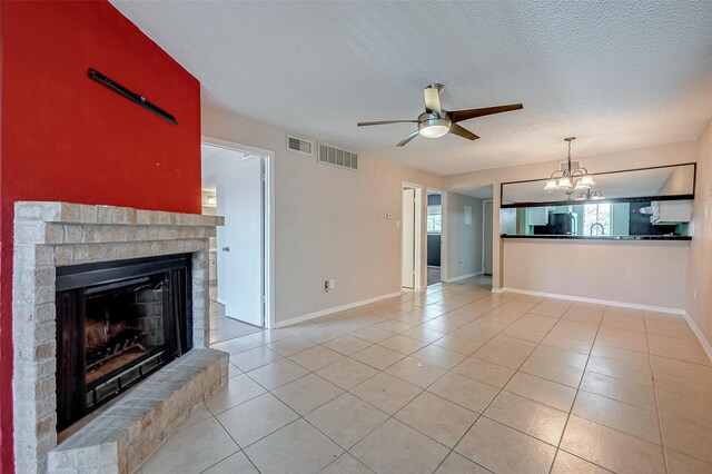 1505 Ward Rd Unit 214, Baytown, TX 77520 - unfurnished living room featuring ceiling fan with notable chandelier, visible vents, a textured ceiling, and a fireplace