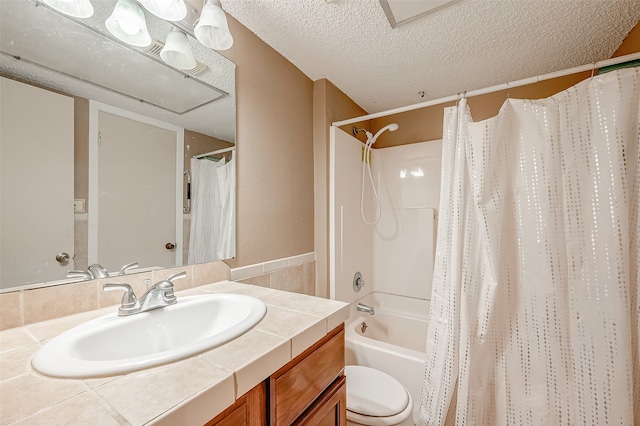 full bathroom with vanity, shower / bath combo with shower curtain, toilet, and a textured ceiling