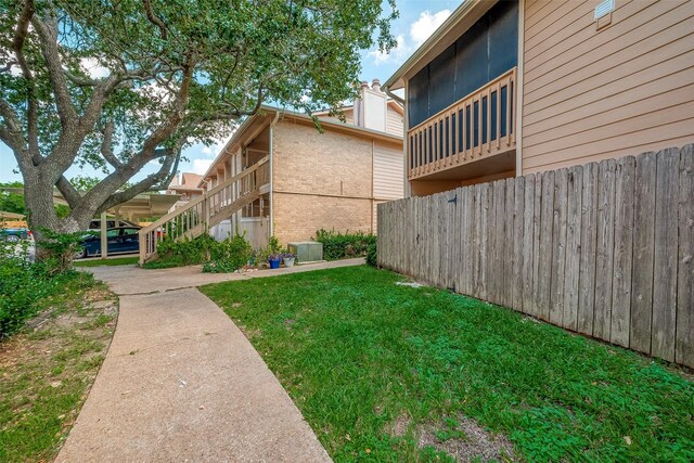 1505 Ward Rd Unit 214, Baytown, TX 77520 - view of yard featuring central AC unit, fence, and stairs