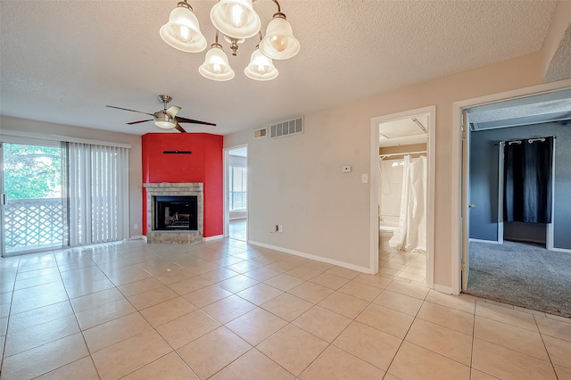 unfurnished living room with ceiling fan with notable chandelier, a textured ceiling, and light tile patterned floors