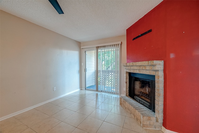 unfurnished living room with a textured ceiling, a fireplace, and light tile patterned flooring