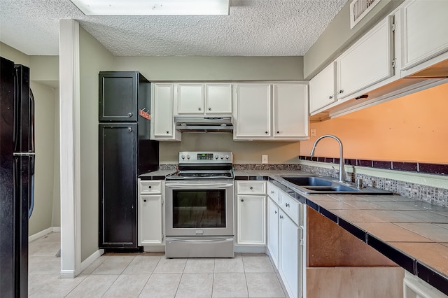 kitchen featuring tile countertops, sink, electric range, and white cabinetry