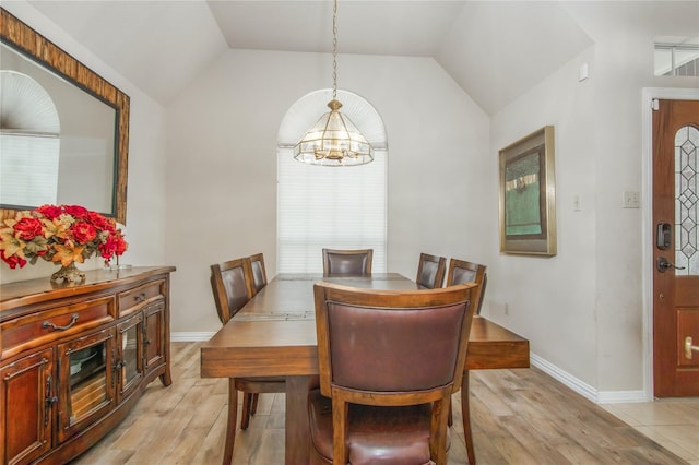 dining room with vaulted ceiling, a notable chandelier, and light hardwood / wood-style floors