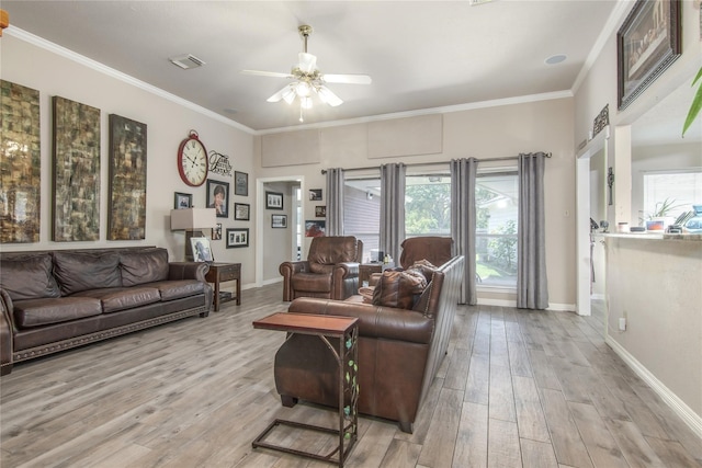 living room featuring ornamental molding, light hardwood / wood-style flooring, and ceiling fan