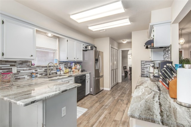 kitchen with light hardwood / wood-style flooring, light stone countertops, white cabinetry, sink, and stainless steel refrigerator with ice dispenser