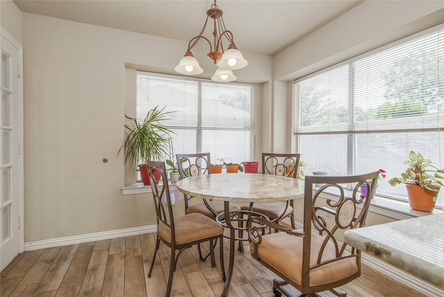 dining area featuring light wood-type flooring and an inviting chandelier