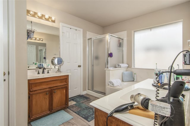 bathroom featuring hardwood / wood-style floors, vanity, and a shower with shower door