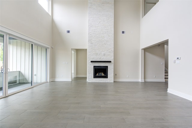 unfurnished living room with a towering ceiling and a fireplace