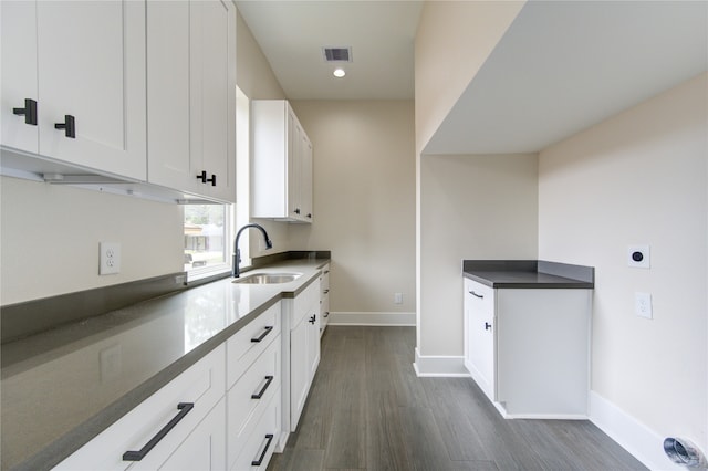 kitchen featuring dark wood-type flooring, white cabinets, and sink