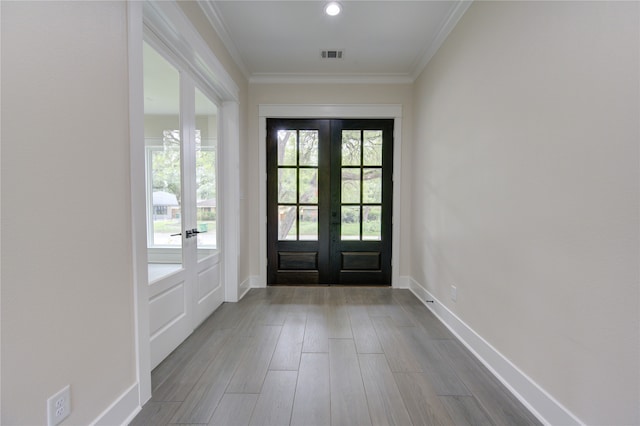 doorway to outside featuring light hardwood / wood-style flooring, ornamental molding, and french doors