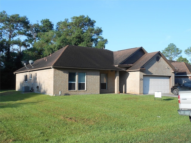 view of front of home with a front lawn, cooling unit, and a garage