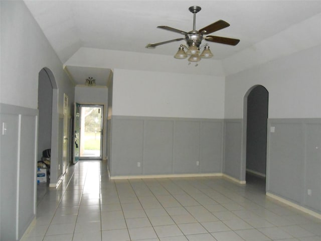 tiled spare room with ceiling fan and vaulted ceiling