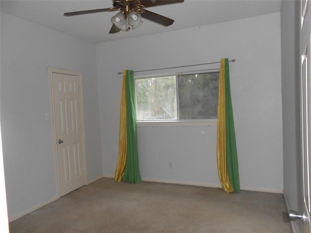 carpeted spare room featuring ceiling fan