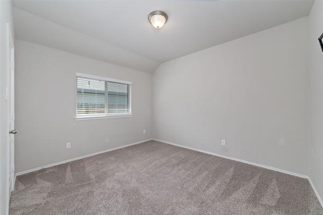 unfurnished room featuring lofted ceiling and carpet flooring