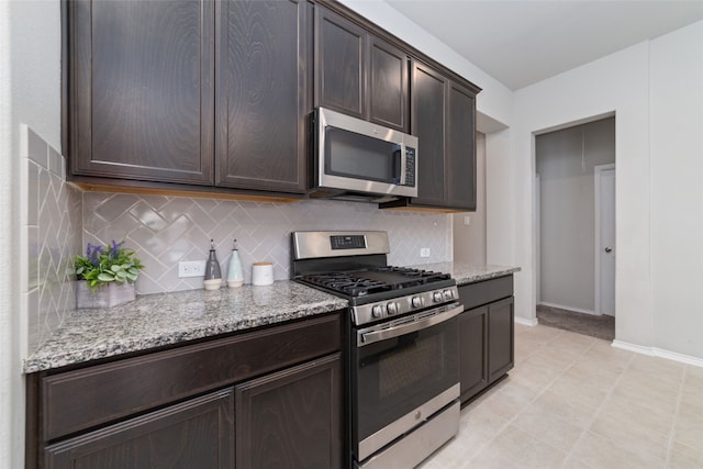 kitchen with stainless steel appliances, light stone counters, dark brown cabinetry, and tasteful backsplash