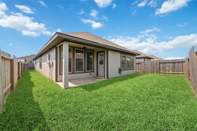 rear view of property featuring a lawn and a patio