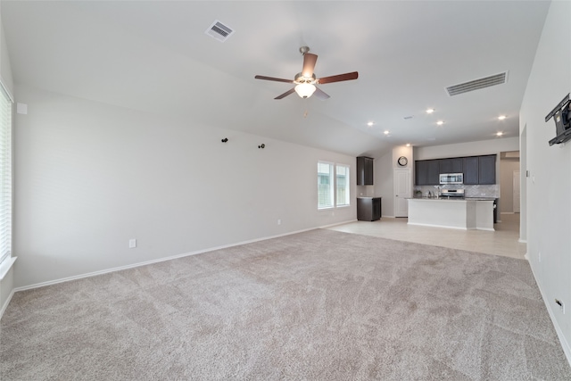 unfurnished living room with lofted ceiling, light colored carpet, and ceiling fan