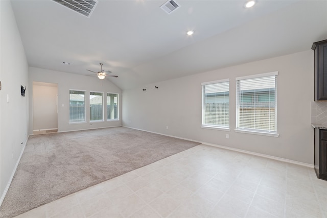 unfurnished living room with light colored carpet, ceiling fan, and vaulted ceiling