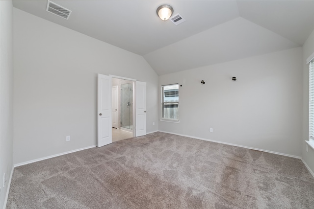 unfurnished bedroom featuring lofted ceiling and carpet flooring