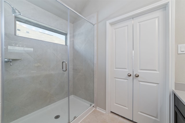 bathroom featuring vanity, a shower with shower door, and tile patterned flooring