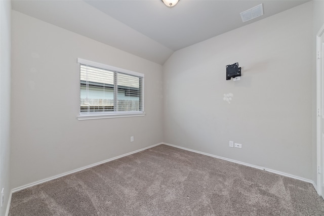 carpeted empty room with vaulted ceiling