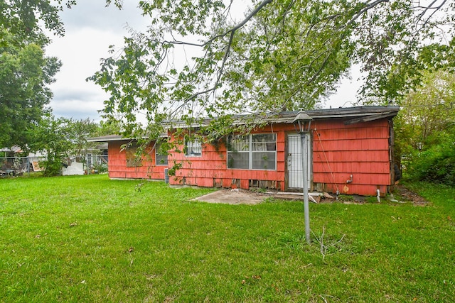 rear view of property with a yard