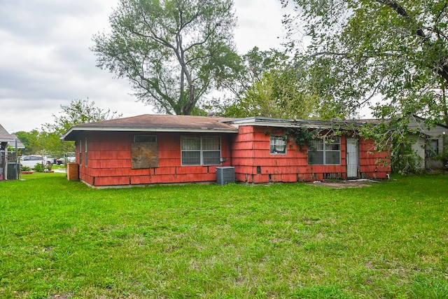 back of house featuring a lawn and central AC unit