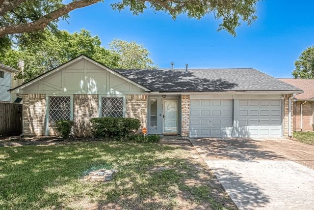 single story home with a garage and a front lawn