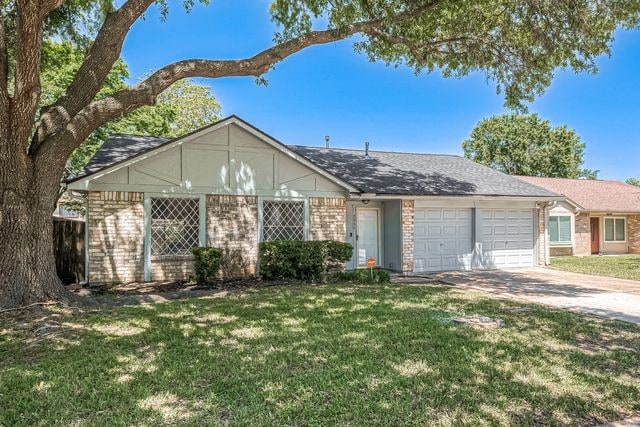 ranch-style house featuring a garage and a front lawn