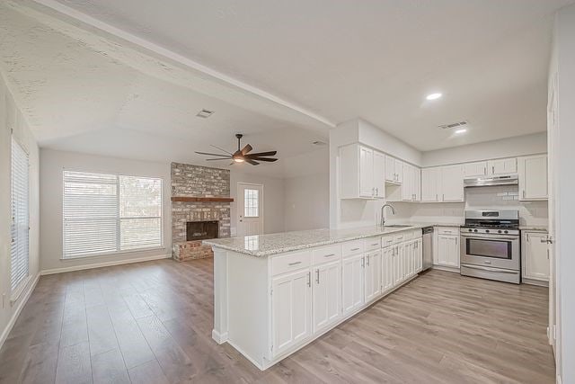 kitchen featuring white cabinets, ceiling fan, stainless steel appliances, and kitchen peninsula