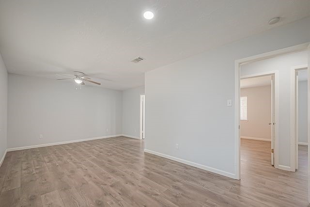 empty room featuring ceiling fan and light hardwood / wood-style floors