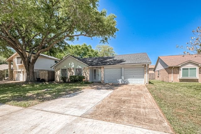 ranch-style house featuring a front lawn and a garage