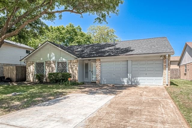 single story home featuring a front yard and a garage