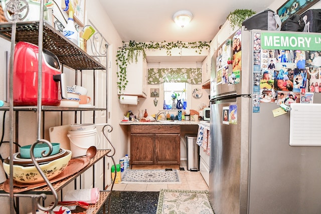 kitchen with sink, stainless steel refrigerator, and light tile patterned flooring