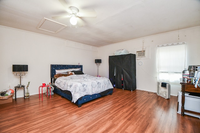 bedroom with crown molding, ceiling fan, hardwood / wood-style flooring, and a wall mounted air conditioner