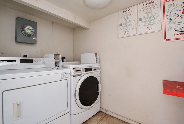 clothes washing area featuring light tile patterned floors and washer and clothes dryer