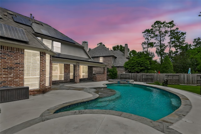 pool at dusk featuring a patio