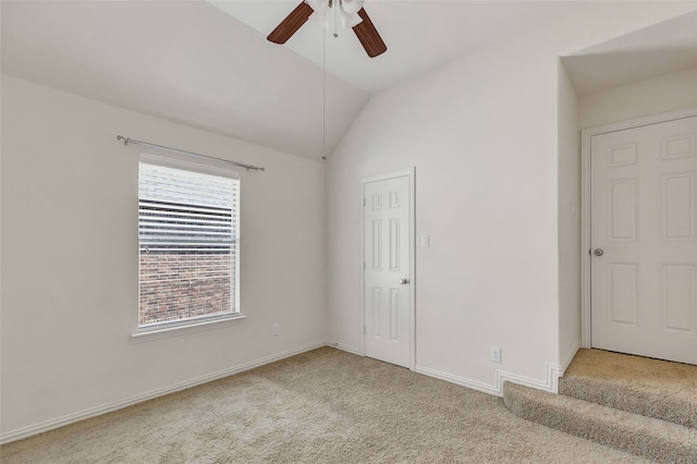 unfurnished bedroom featuring lofted ceiling, light colored carpet, ceiling fan, and multiple windows