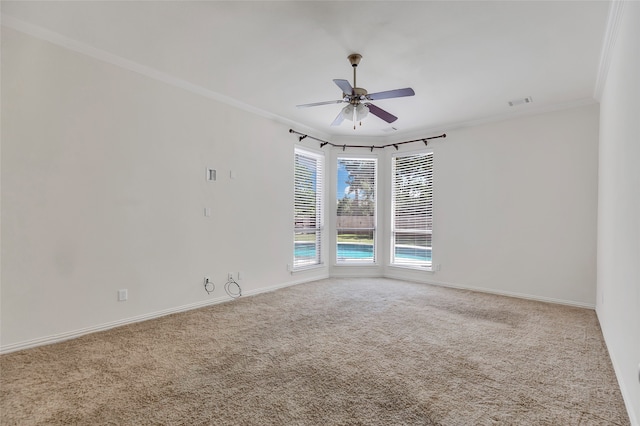 carpeted empty room with ceiling fan and ornamental molding