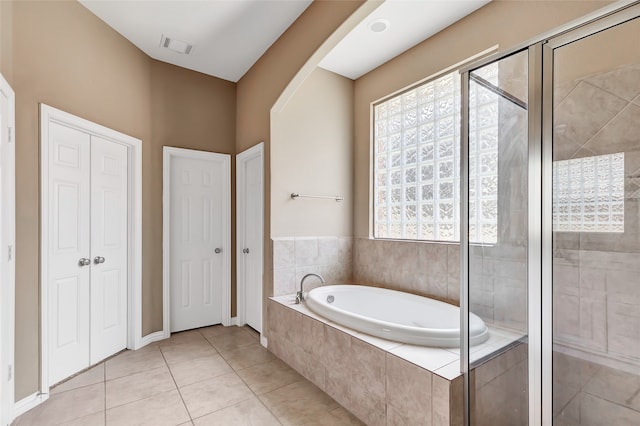 bathroom featuring tile patterned flooring, a healthy amount of sunlight, and independent shower and bath