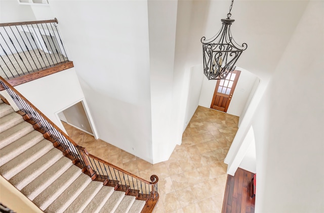 entrance foyer featuring a notable chandelier, a towering ceiling, and light tile patterned flooring