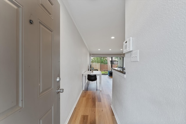 hall featuring light wood-type flooring and ornamental molding